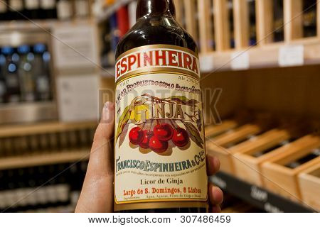 Porto, Portugal: Bottle Of Popular Cherry Liquor Ginja In The Hands Of The Buyer Of An Alcohol Store