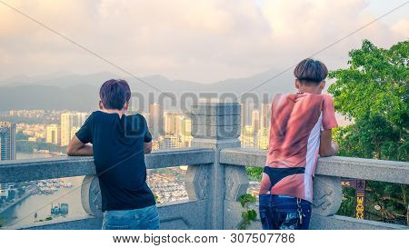 Sanya, Hainan Island, China - May 16, 2019: Two Young Unidentified Guys Look At The Panorama Of Sany