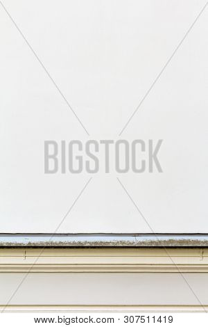 Fragment Of A Solid Wall Of An Old Building With Seams And A Decorative Metal Border. Windowless Wal