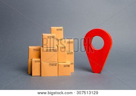 Lots Of Cardboard Boxes And A Red Position Pin. Locating Packages And Goods. Tracking Parcels By The