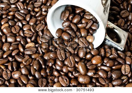 Umgekippte Kaffeetasse mit Kaffeebohnen