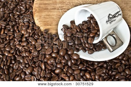 Umgekippte Kaffeetasse mit Kaffeebohnen