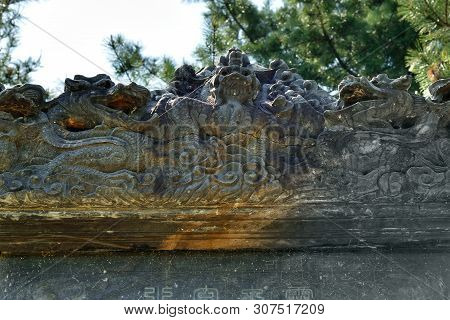 Traditional Korean Stone Carving, Flowers And Dragons Covered With Cobwebs On An Ancient Stone Pagod