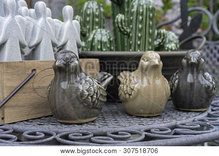 Ceramic Figurines Of Birds In The Gift Shop. Statuette Of A Sparrow For Decoration Of An Interior Or