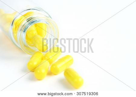 Yellow Capsules From Glass Bottle On White Background. Copyspace For Text. Epidemic, Painkillers, He