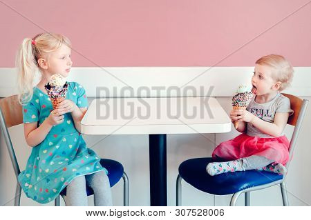 Lifestyle Portrait Of Two Happy Caucasian Cute Adorable Funny Children Girls Sitting Together Braggi