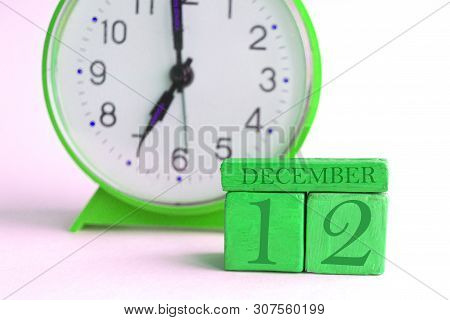 December 12th. Day 12 Of Month, Handmade Wood Calendar And Alarm Clock On Light Green Color. Winter 