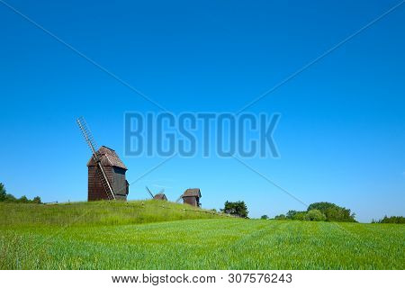 Rural Landscape With Historical Windmills Behind Wheet Field In Spring, Copy-space On The Sky