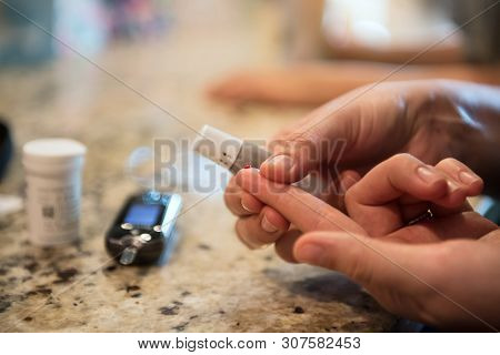Woman Using Diabetes Healthcare Blood Sugar Glucose Measurement System At Home