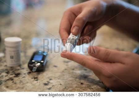 Woman Using Diabetes Healthcare Blood Sugar Glucose Measurement System At Home