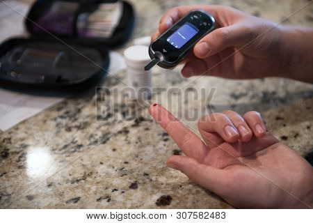 Woman Using Diabetes Healthcare Blood Sugar Glucose Measurement System At Home