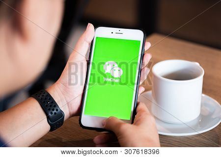 Chiang Mai / Thailand - June 22 2019 : Hands Holding Mobile With Wechat Screen In Coffee Shop.