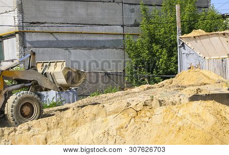 Tractor Collects Scoop With  Gravel. Excavator Extracts Sand And Gravel For  Concrete Mix.