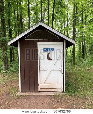 Outhouse With Sign For Male Female Or Disabled On The Door