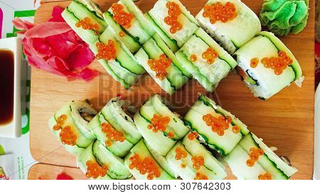 Sushi Rolls With Philadelphia Cheese, Salmon And Avocado Wrapped In Cucumber. Japanese Sushi Concept