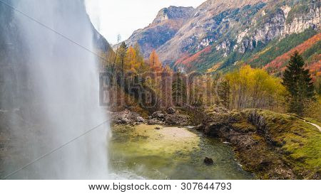 Waterfall In An Autumn Day In The Italian Alps