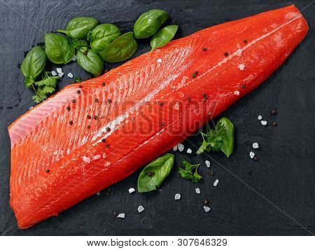 Fresh Raw Copper River Sockeye Salmon Fillet On Natural Stone With Herbs And Seasoning