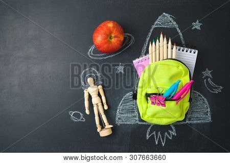 Back To School Concept With Small Bag Backpack, School Supplies And Rocket Sketch Over Chalkboad Bac