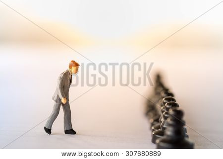 Business Work And Planning Concept. Close Up Of Businessman Miniature Figure Walking To Row Of Black
