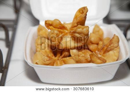 A Stack Of Crab Rangoons In A Carryout Box