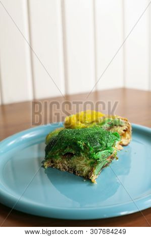 Square Piece Of Green And Gold Covered King Cake