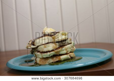 Stack Of Pancakes Topped With Butter And Slathered In Syrup