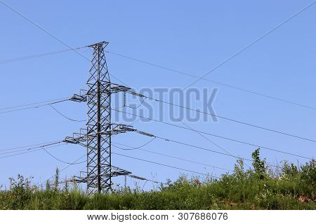 High Voltage Power Line Tower With Electrical Wires On Blue Sky Background. Electricity Transmission