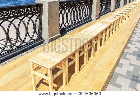 Wooden Backless Stools Stand In A Row On The City Embankment