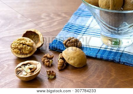 Whole Walnuts And Walnut Kernel Halves Without Shell On A Dark Wooden Table And Checkered Towel, Clo