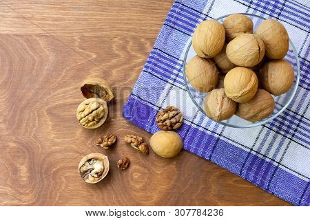 Whole Walnuts And Walnut Kernel Halves Without Shell On A Dark Wooden Table And Checkered Towel, Clo