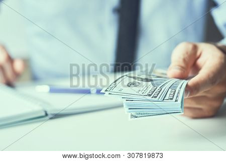Man Giving Money Us Dollar Banknotes And Holding Cash In Hands. Money Credit Concept. Toned Picture.