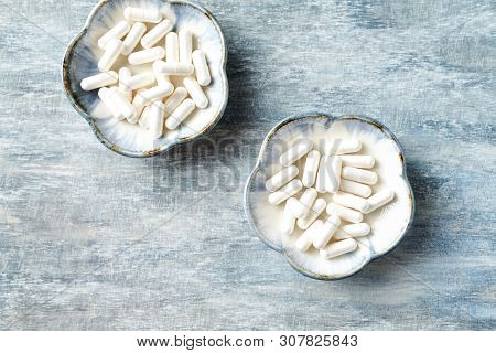 Theanine Capsules. Dietary Supplement.   Rustic Wooden Background. Top View. Copy Space.