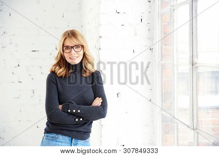 Beautiful Smiling Woman Standing With Arms Crossed While Relaxing At The Window