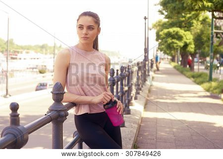 Shot Of Young Woman Holding A Shaker In Her Hand While Relaxing After Running In The City.