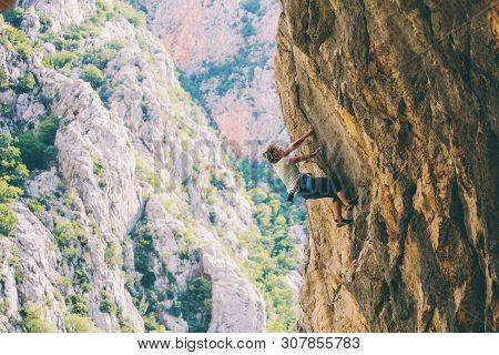 Rock Climbing And Mountaineering In The Paklenica National Park. A Woman Overcomes A Challenging Cli