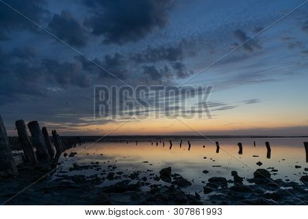 Sunset On The Kuyalnik Liman. Odessa. Ukraine. Old Logs Are Visible From The Water - The Remains Of 
