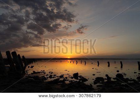 Sunset On The Kuyalnik Liman. Odessa. Ukraine. Old Logs Are Visible From The Water - The Remains Of 