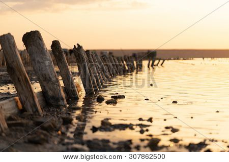 Sunset On The Kuyalnik Liman. Odessa. Ukraine. Old Logs Are Visible From The Water - The Remains Of 