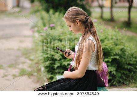 Young Girl Use Phone During School Break. Girl Play Online Games