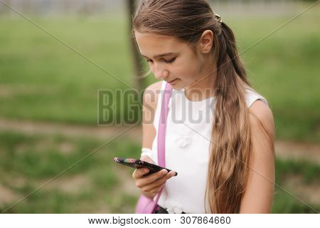 Young Girl Use Phone During School Break. Girl Play Online Games
