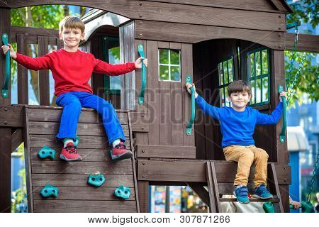 Two Little Boys Playing Together And Having Fun. Lifestyle Family Moment Of Siblings On Playground.
