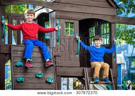 Two Little Boys Playing Together And Having Fun. Lifestyle Family Moment Of Siblings On Playground.