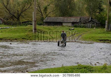Altai Region, Russia - September 4, 2018: Local Residents Wade Through A Mountain River Yarivka In T