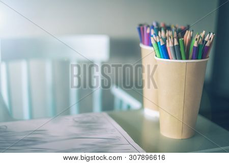 Stack Of Colored Pencils In A Glass On Childrens Table, Next To A High Chair , Right, A Cozy Place T