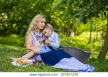 Portrait Of Happy Caucasian Mother With Her Upset Little Kid. Posing With Basket Full Of Bread Rings