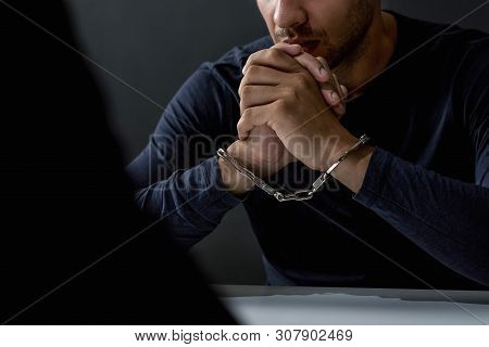 Criminal Man With Handcuffs In Interrogation Room Being Interviewed After Committed A Crime