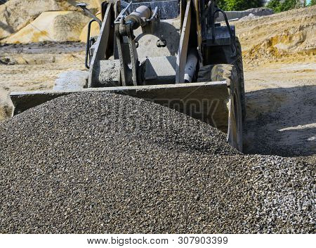 Tractor Collects Scoop With  Gravel. Excavator Extracts Sand And Gravel For  Concrete Mix.