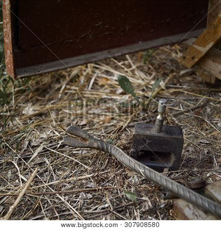 A Pry Bar And Picked Lock Abandoned On The Ground Next To The Open Metal Door, Concept Of Unsafety