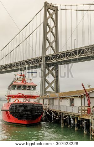 San Francisco Fireboat Moored With The Bay Bridge In The Background.