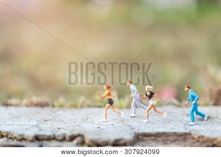Miniature People : Running On The Road With Nature Background , Health And Lifestyle Concepts